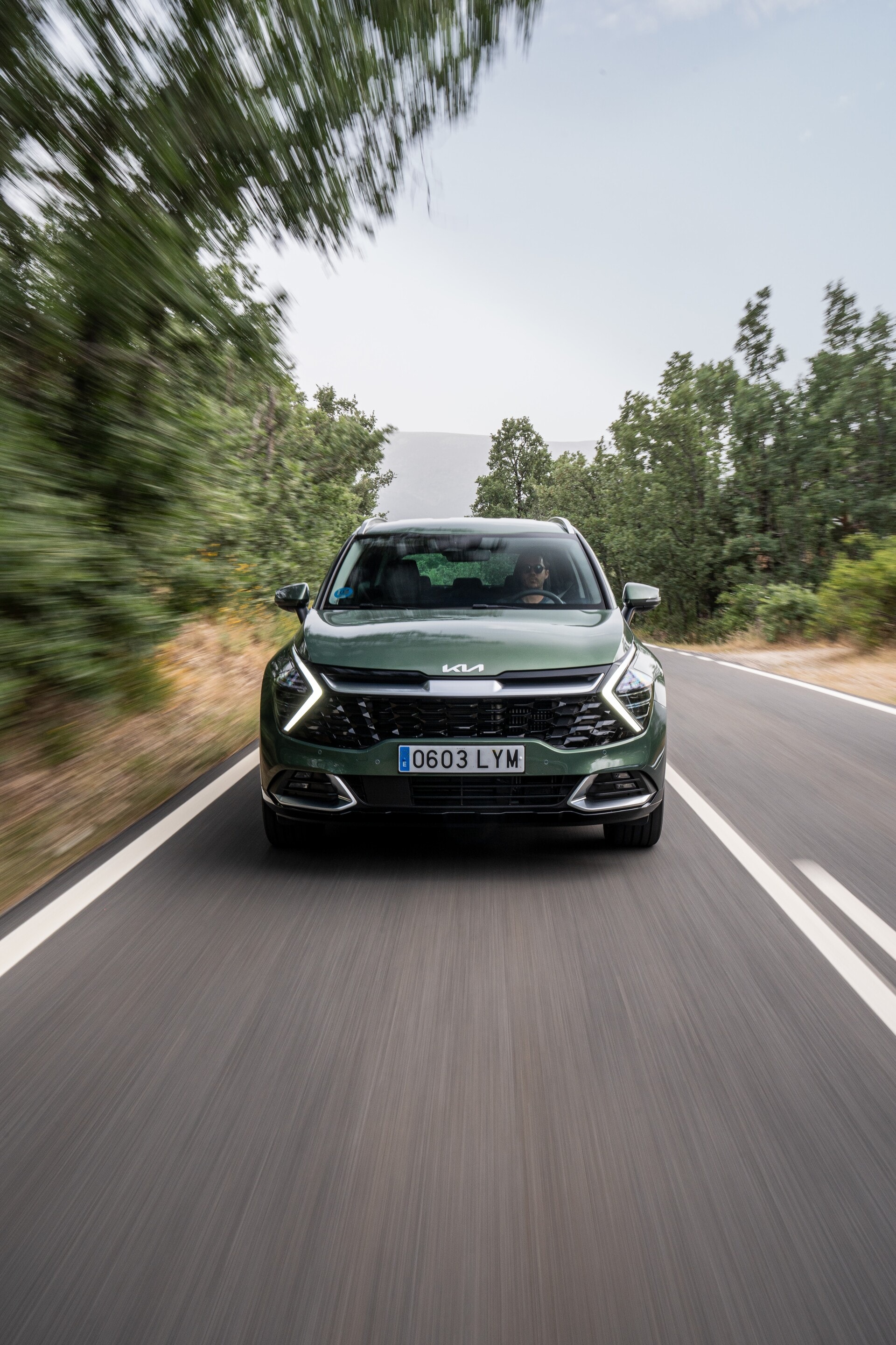 Vista dinámica frontal del Kia Sportage híbrido en pleno movimiento.
