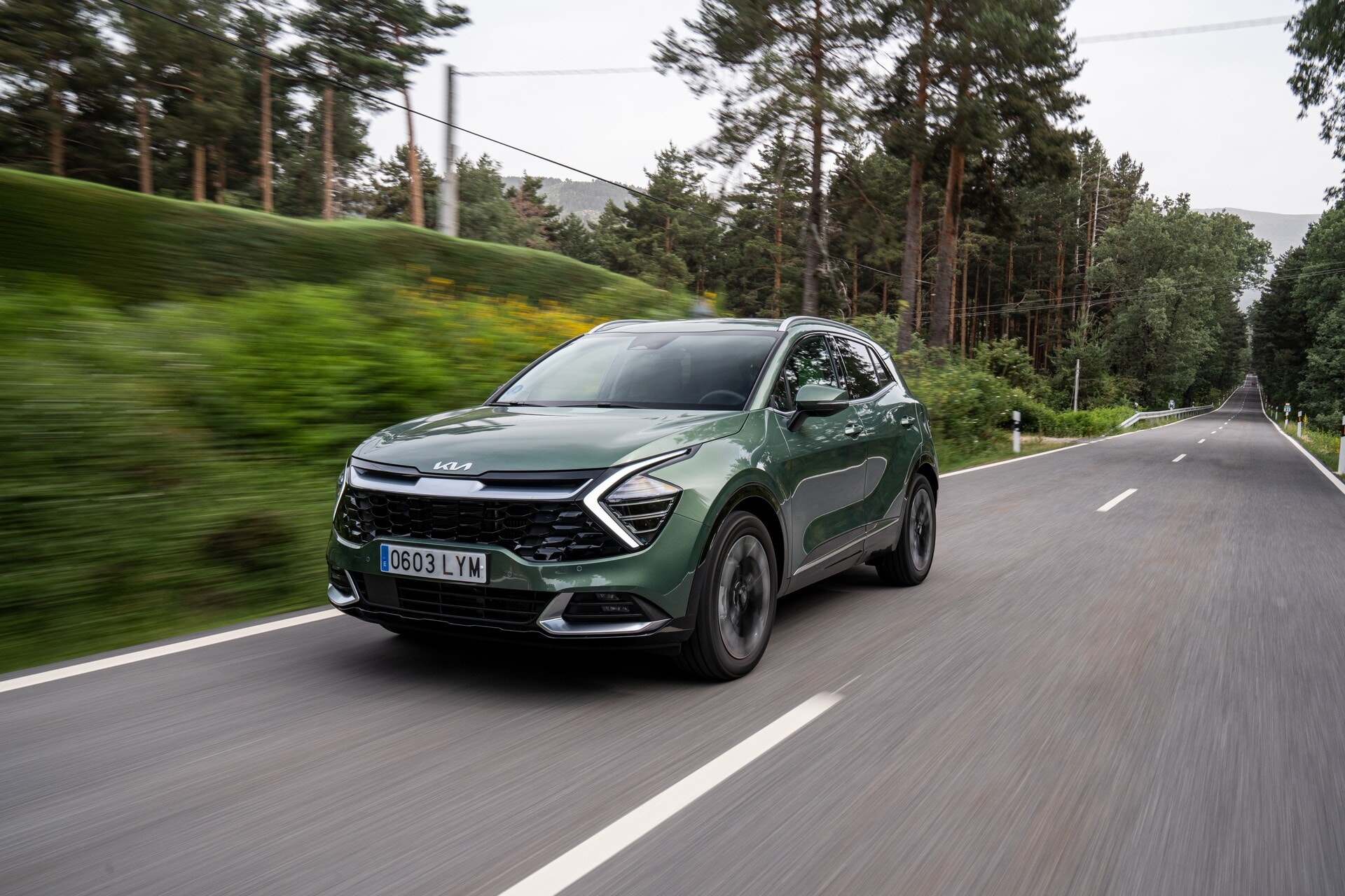 El Kia Sportage híbrido capturado en movimiento, destacando su dinamismo.