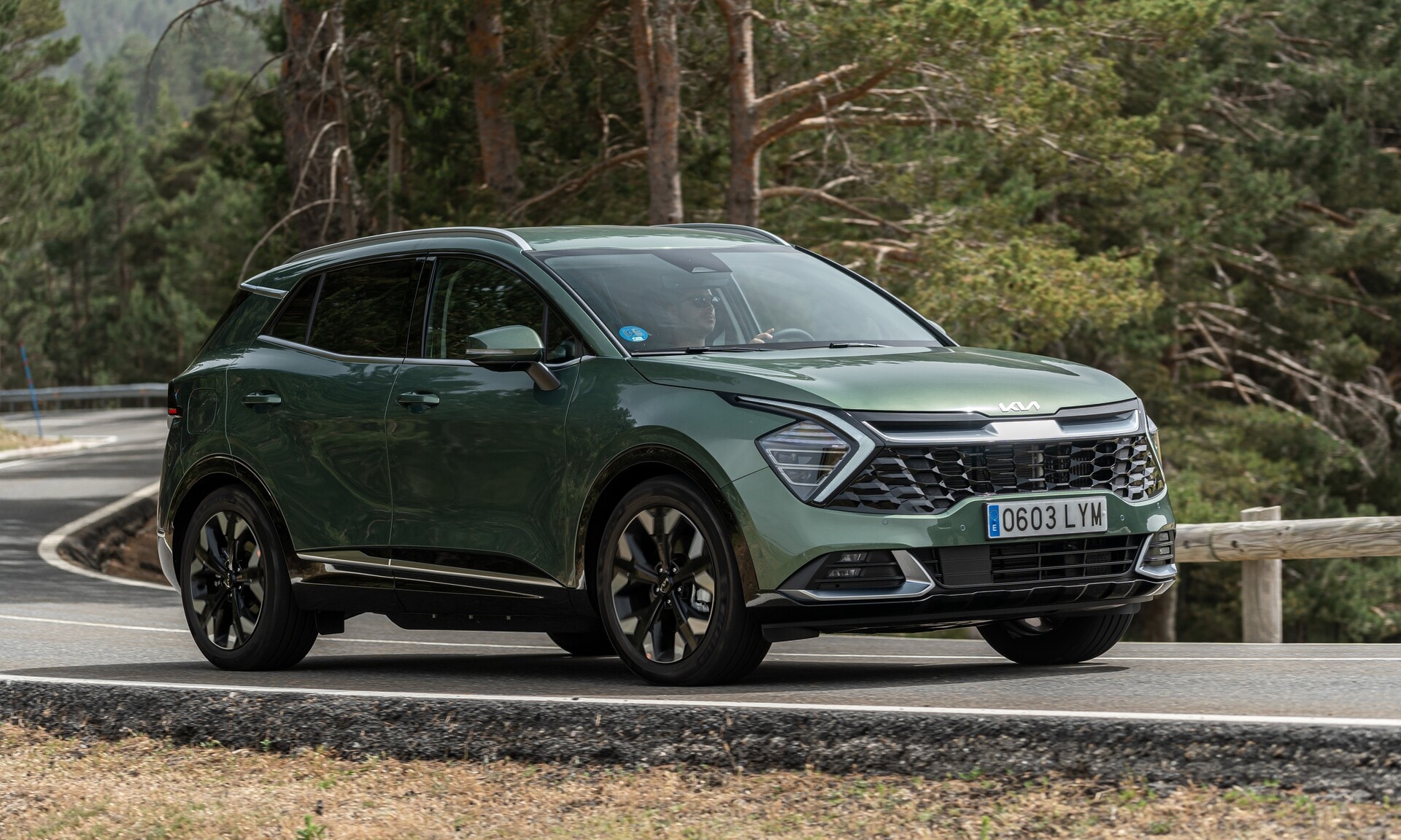 Vista lateral del Kia Sportage híbrido en carretera.