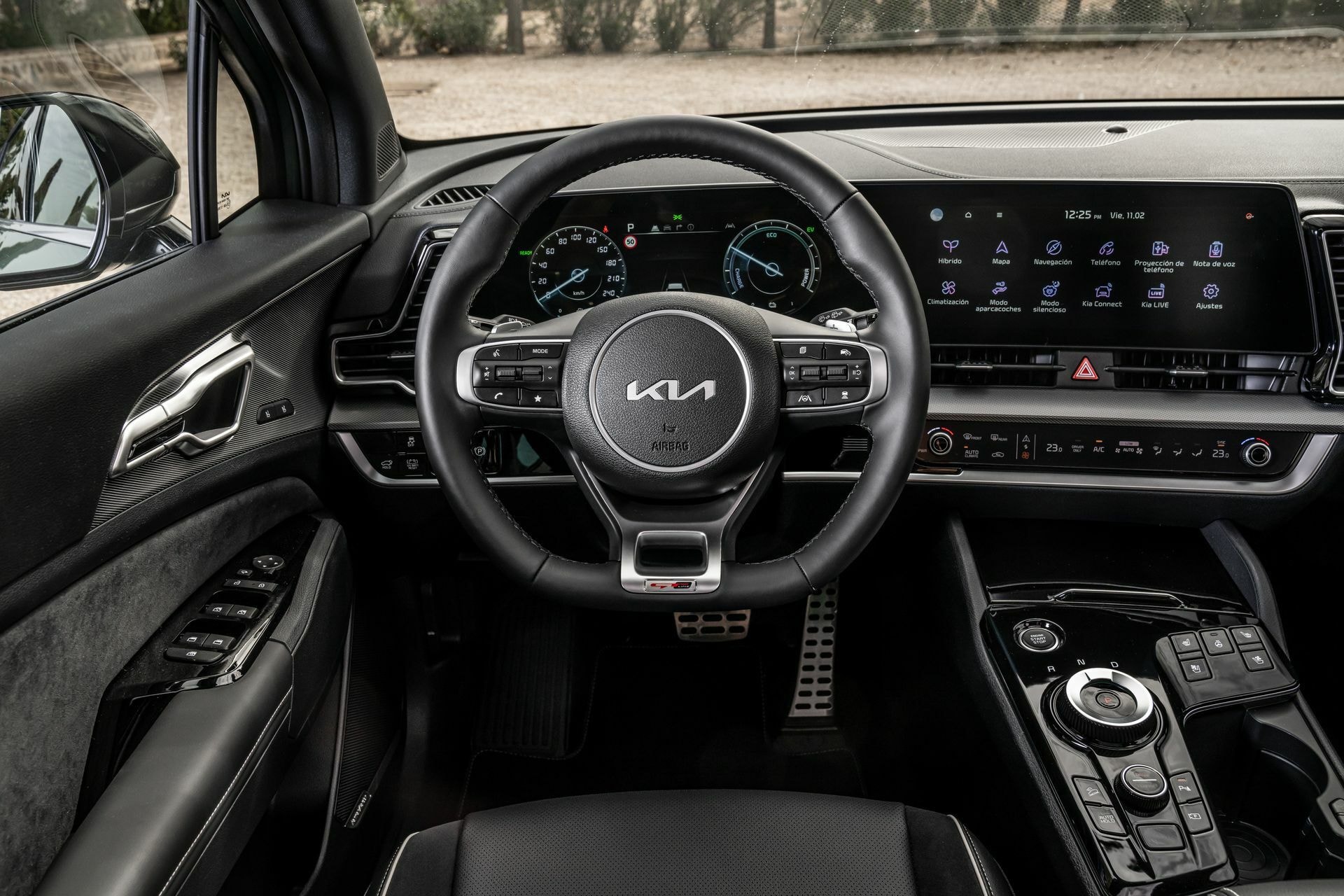 Perspectiva del área de conducción con volante y pantallas.