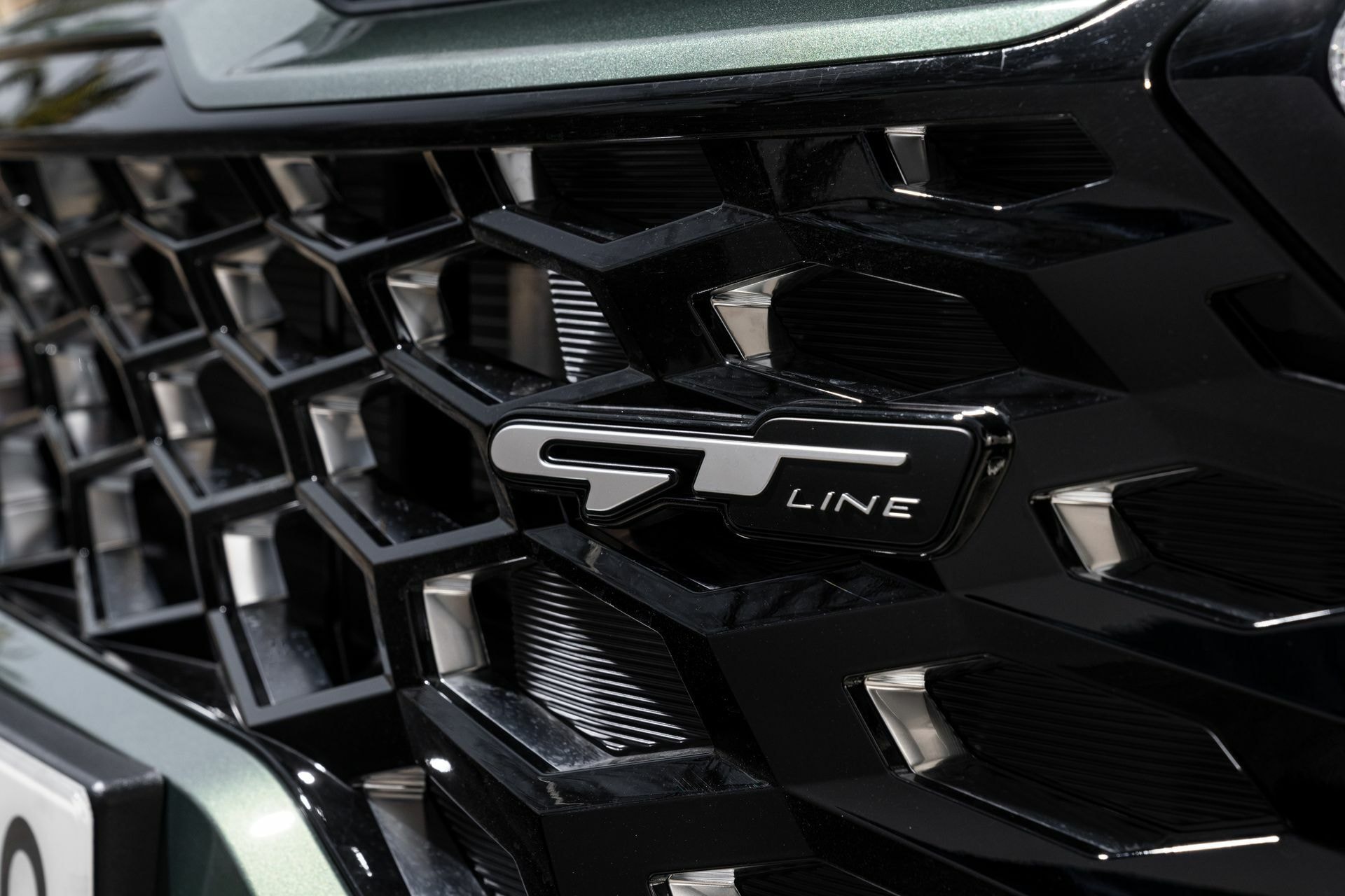 Detalle del emblema GT Line en la parrilla del Kia Sportage.