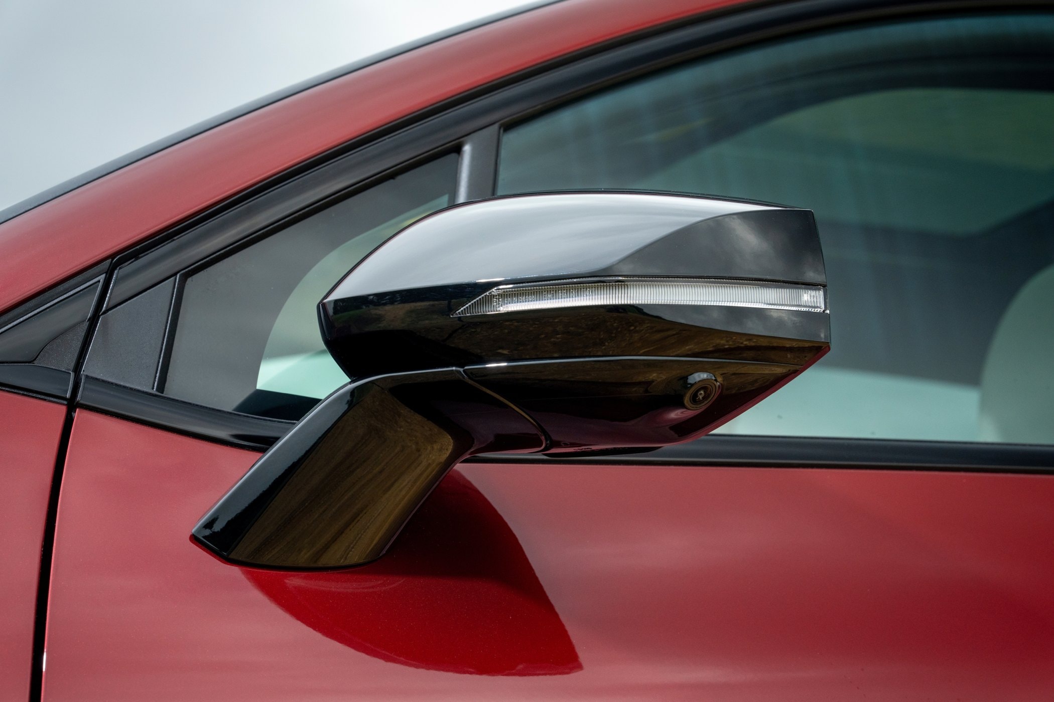 Espejo lateral moderno con detalles en negro y función de luz de giro.