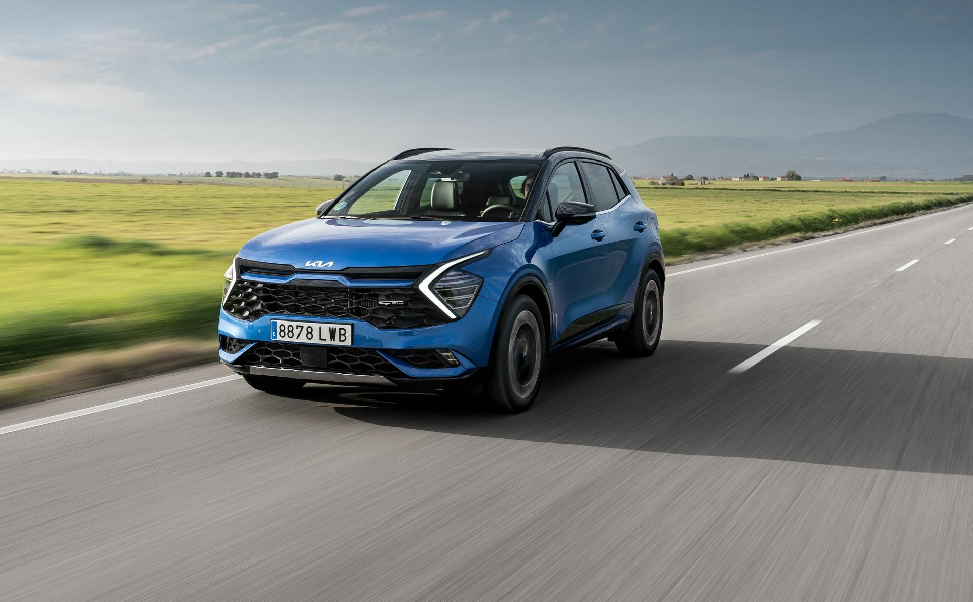 Kia Sportage en movimiento mostrando su línea lateral y frontal
