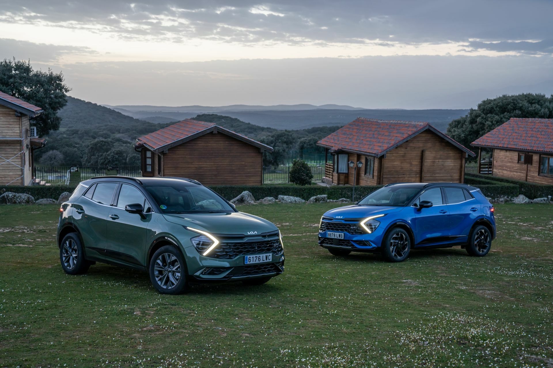 Dos modelos de Kia Sportage en entorno natural al atardecer