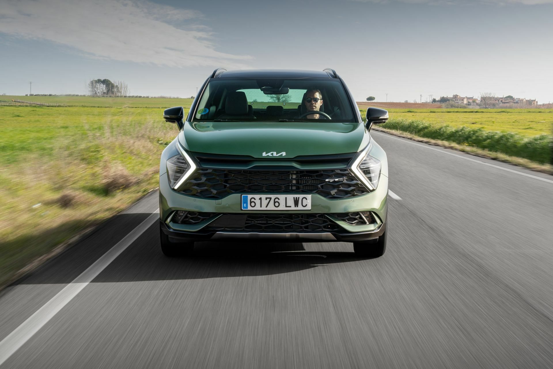 Imagen frontal del Kia Sportage en carretera, muestra detalladamente la parrilla