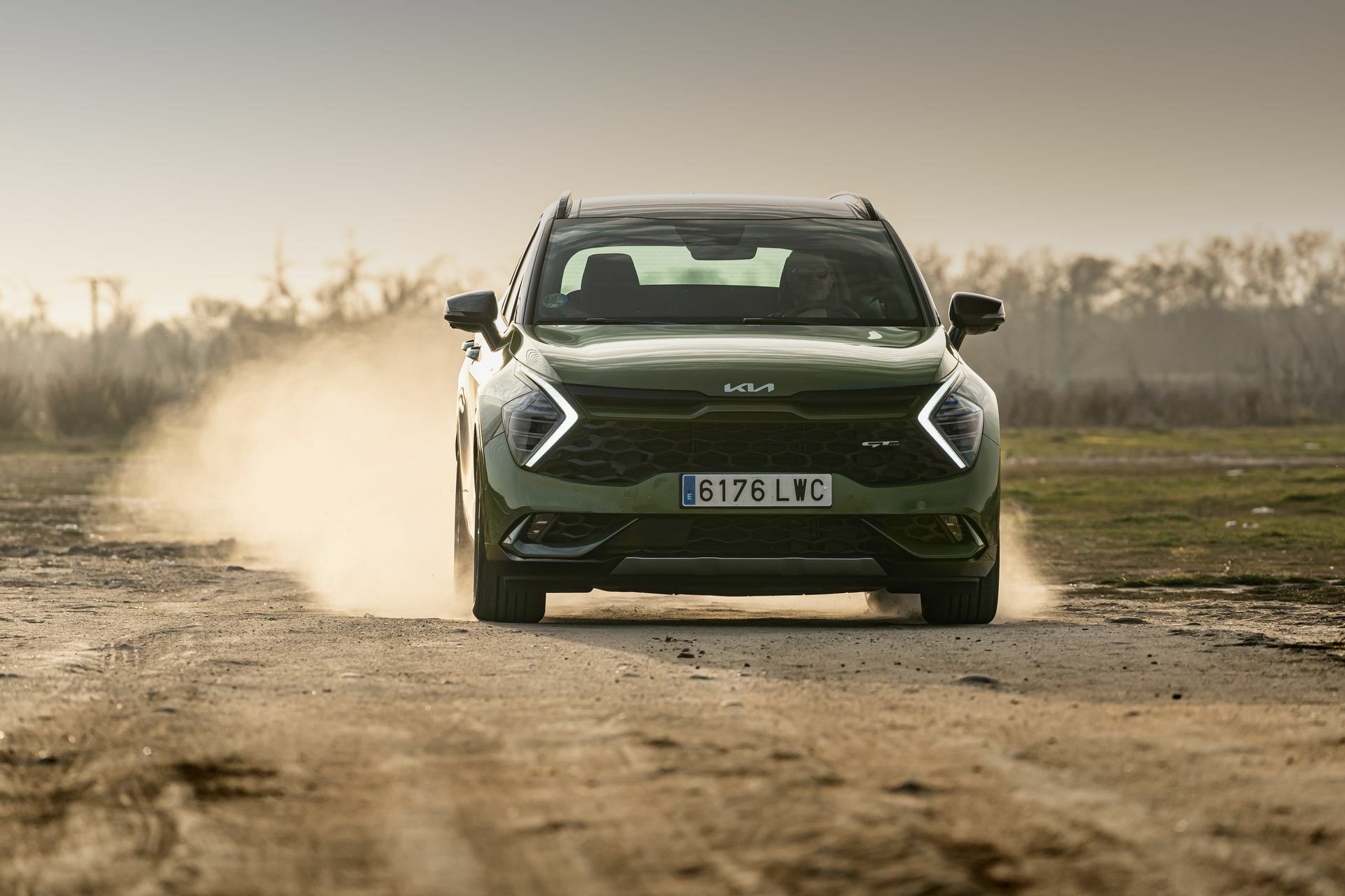 Kia Sportage levantando polvo en superficie no asfaltada