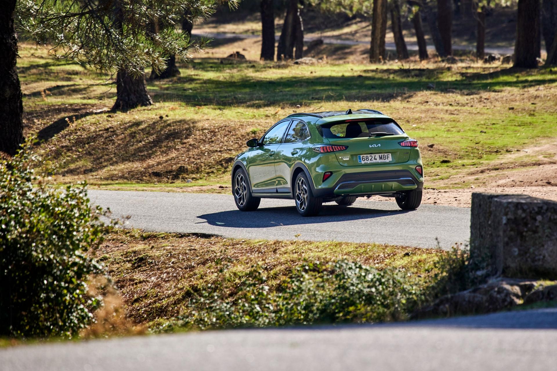 Toma del Kia Xceed Híbrido desde una perspectiva trasera y lateral en carretera