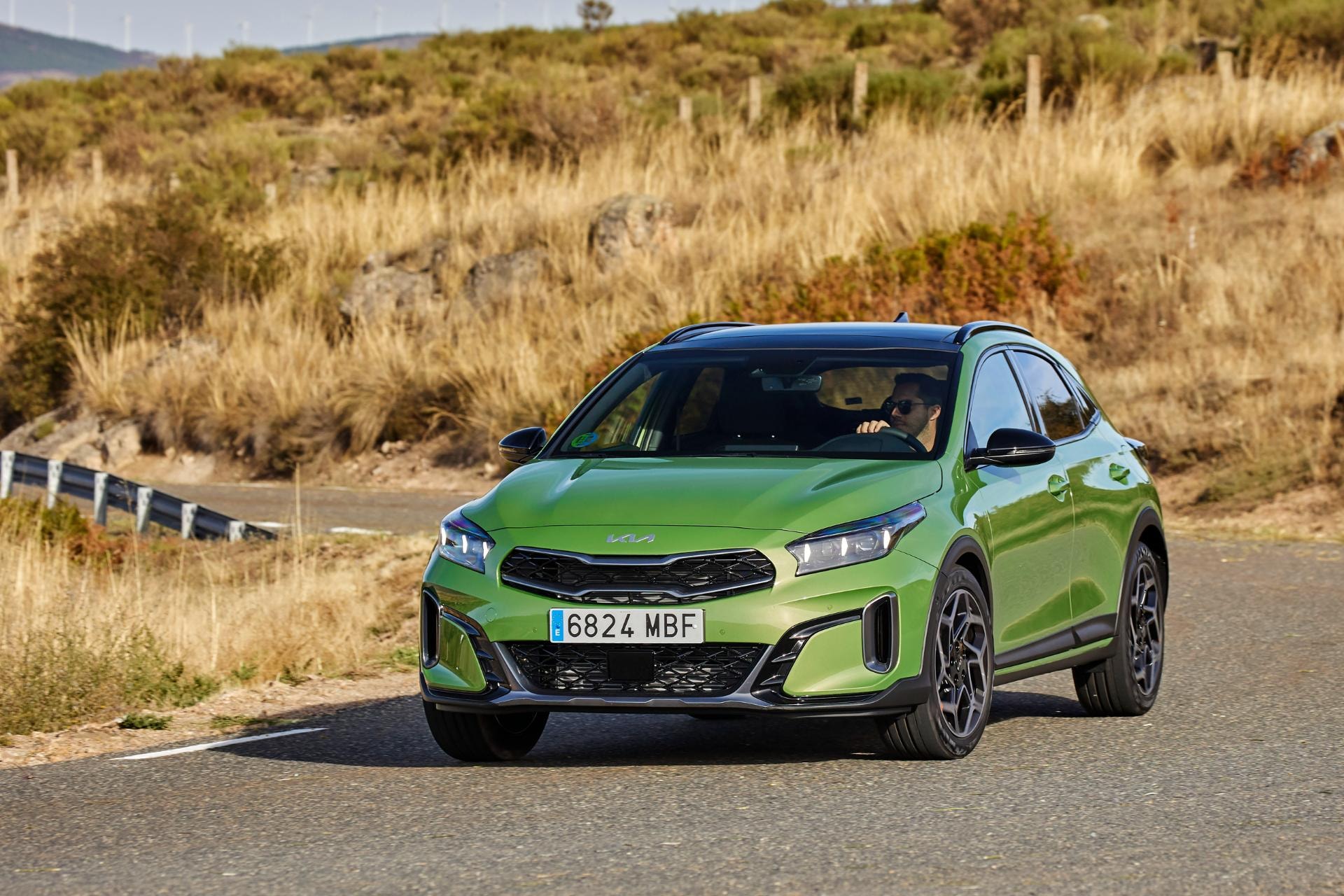 El Kia Xceed Híbrido capturado en una carretera con una pose que subraya su diseño lateral.