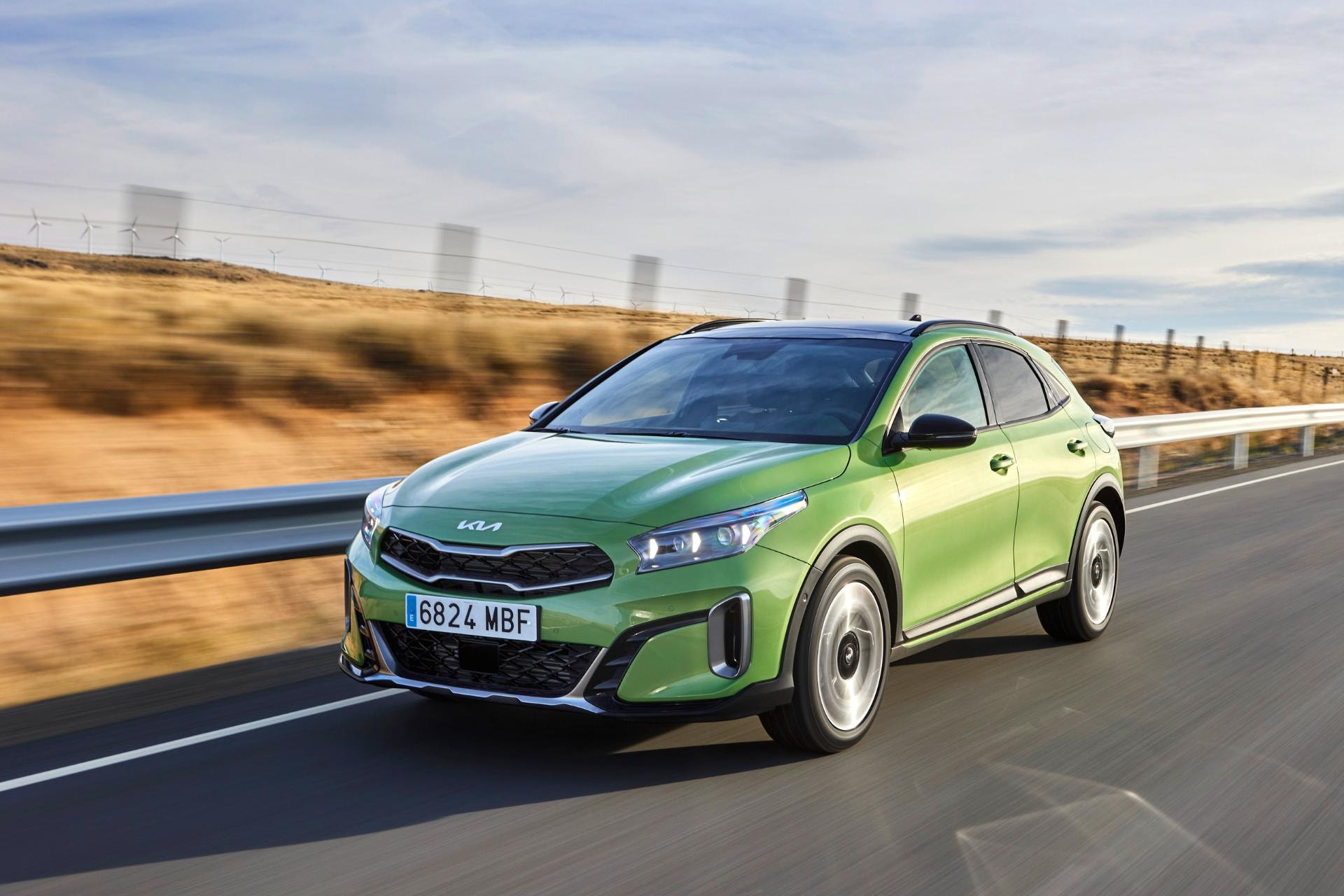 Vista lateral del Kia Xceed Híbrido circulando por una carretera.