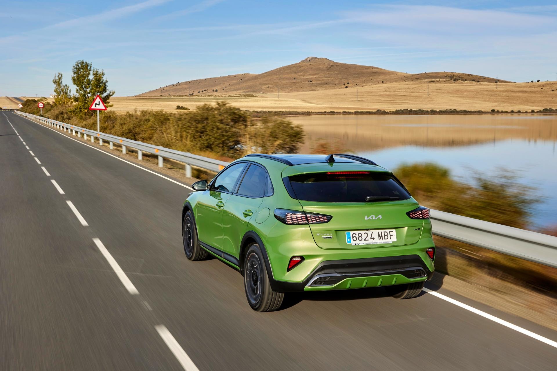 Imagen del Kia Xceed Híbrido desde un ángulo trasero lateral en carretera.