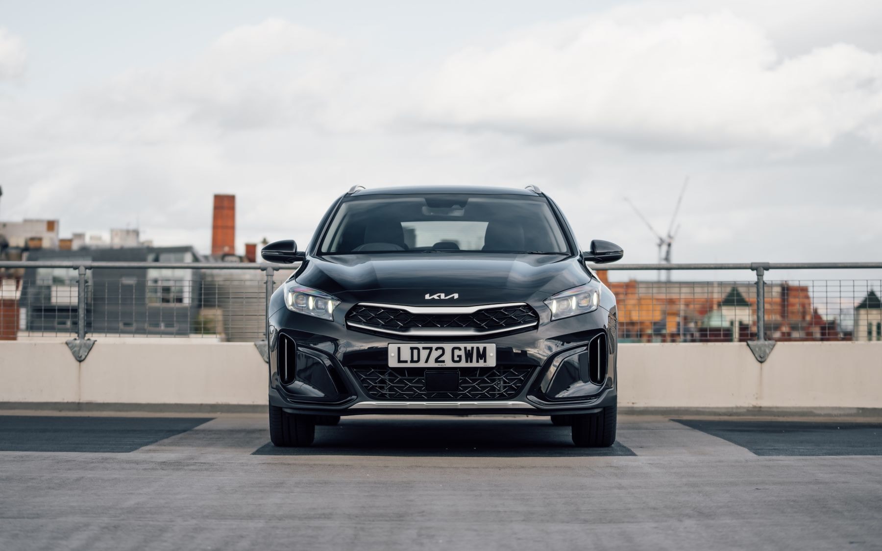 Primer plano del logotipo Kia en el capó, símbolo de calidad.