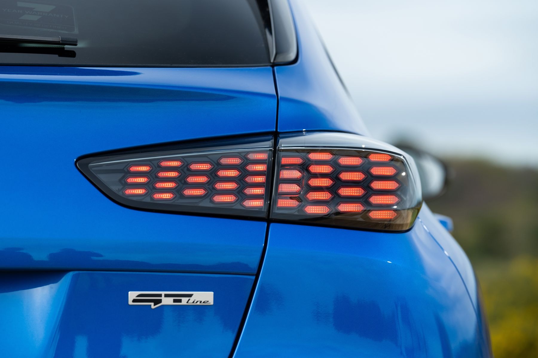 Detalle del logotipo de Kia, símbolo de calidad y modernidad.