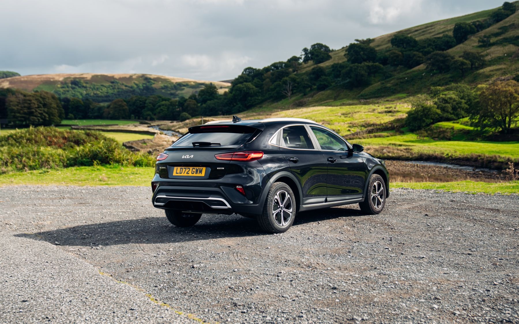 Vista trasera del Kia Xceed en un paisaje natural, fusionando elegancia y naturaleza.