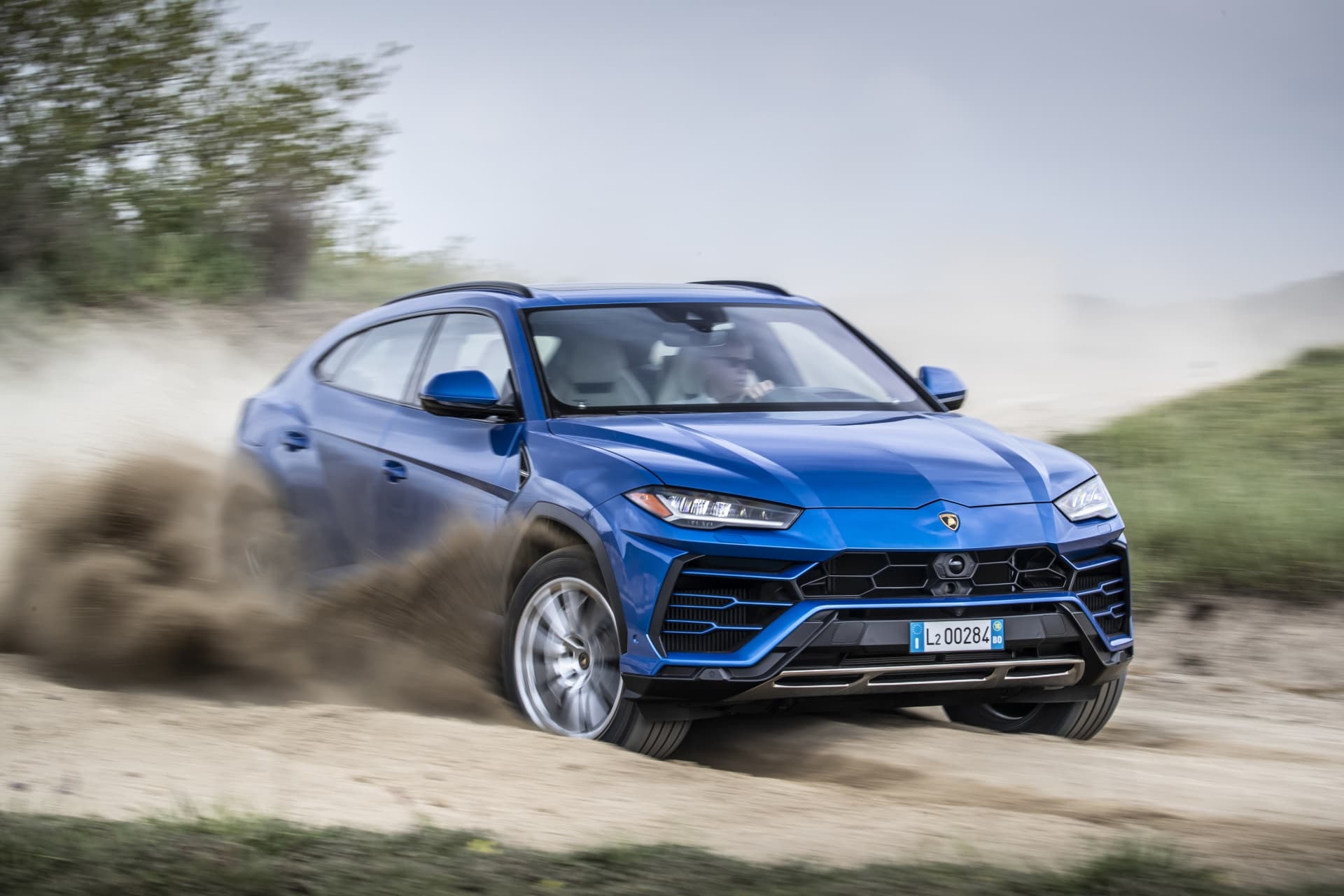 Lamborghini Urus azul en movimiento, demostrando agilidad y fortaleza en un entorno natural.
