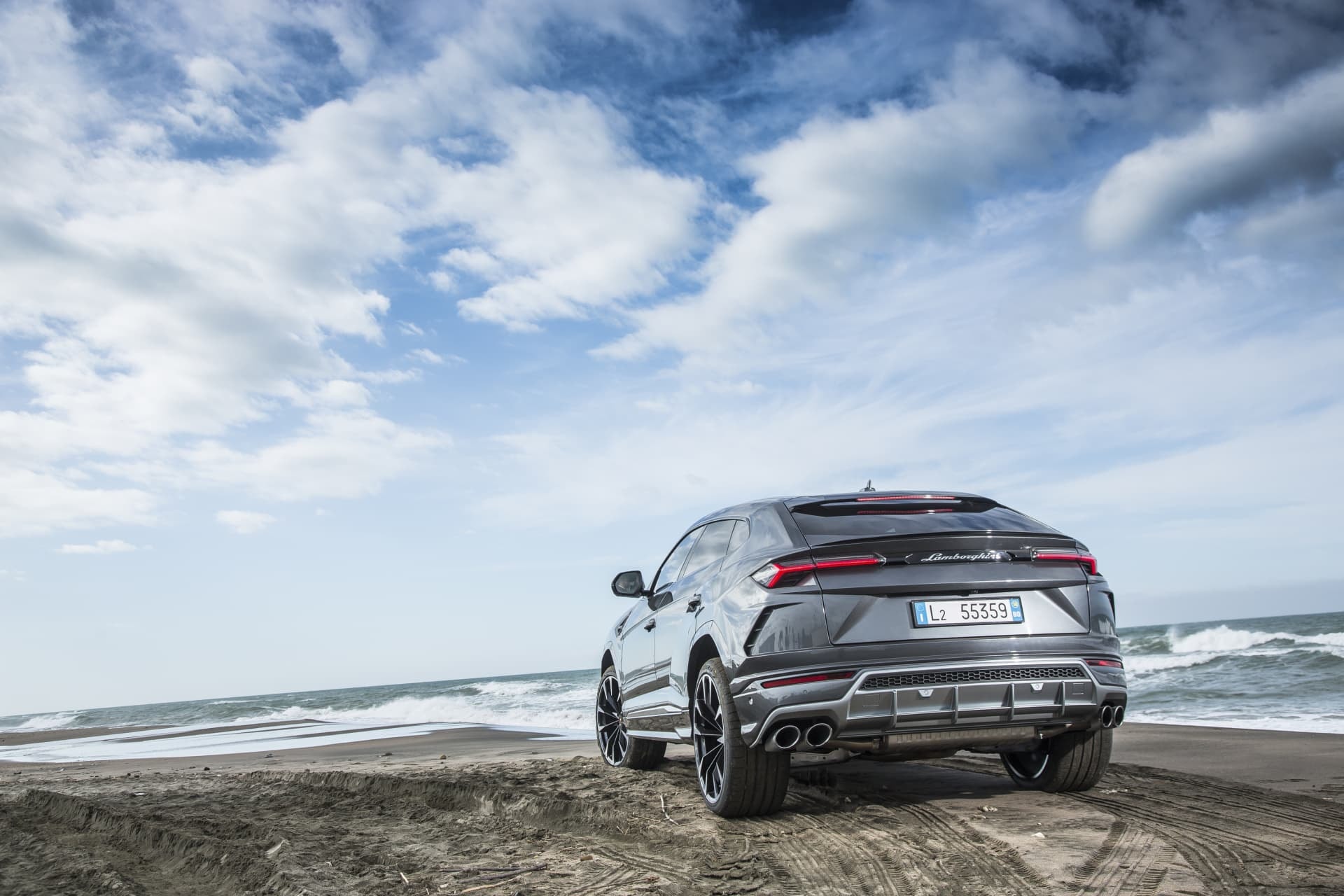Trasera y perfil lateral del Urus rojo demostrando su capacidad en carreteras curvas.