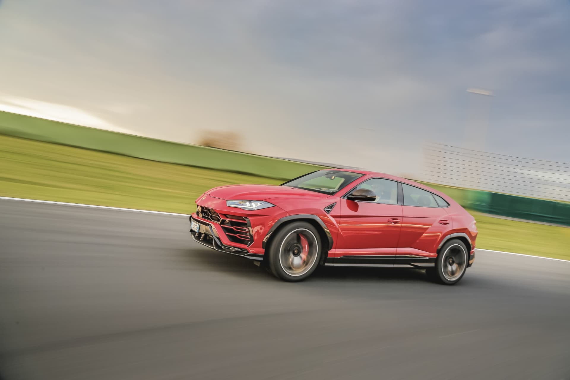 Perfil del Urus rojo, capturando la esencia de su velocidad y elegancia en diseño.