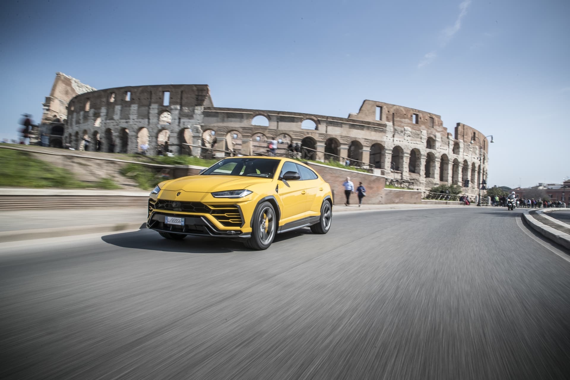 Atractiva toma dinámica del Urus amarillo pasando por el Coliseo.