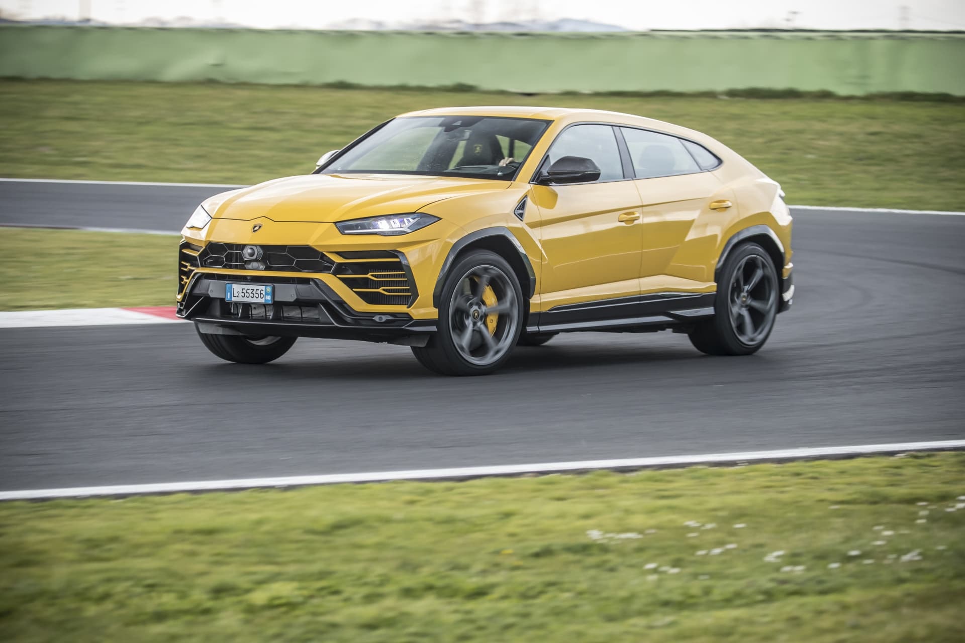 Perfil del Lamborghini Urus en amarillo, destacando su diseño agresivo y llantas deportivas.