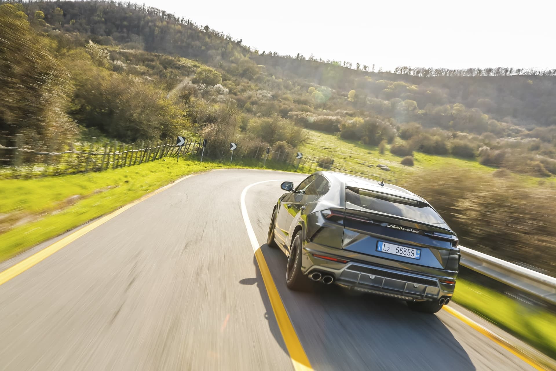 Perspectiva trasera del Lamborghini Urus en una carretera sinuosa.