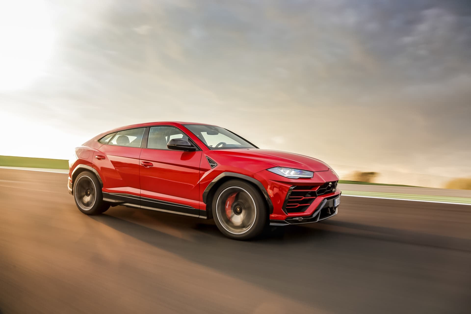 Visión lateral del Urus en rojo, subrayando su estética deportiva y acabados de alto rendimiento.