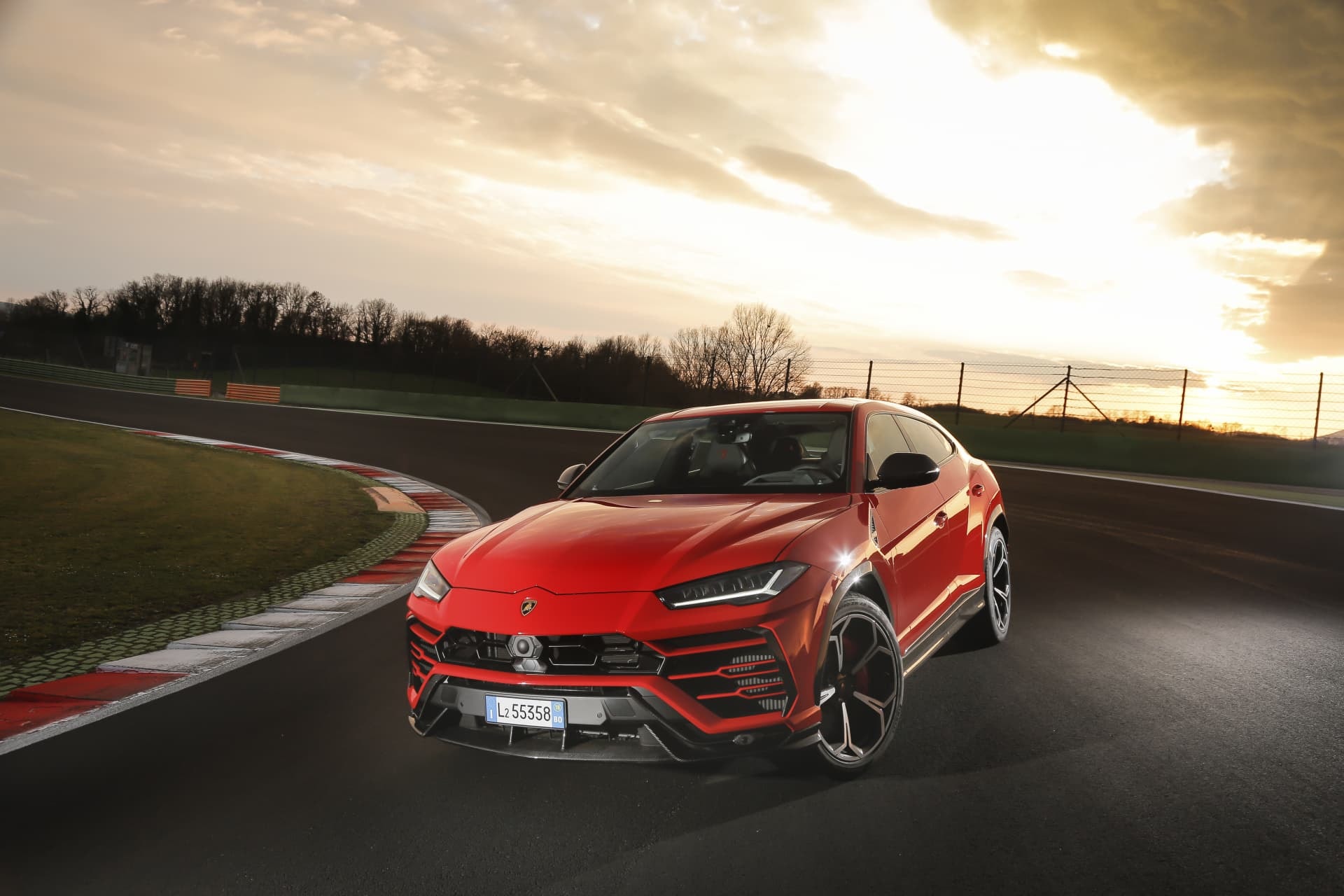 Perfil delantero del Urus en rojo, demostrando su presencia en la pista
