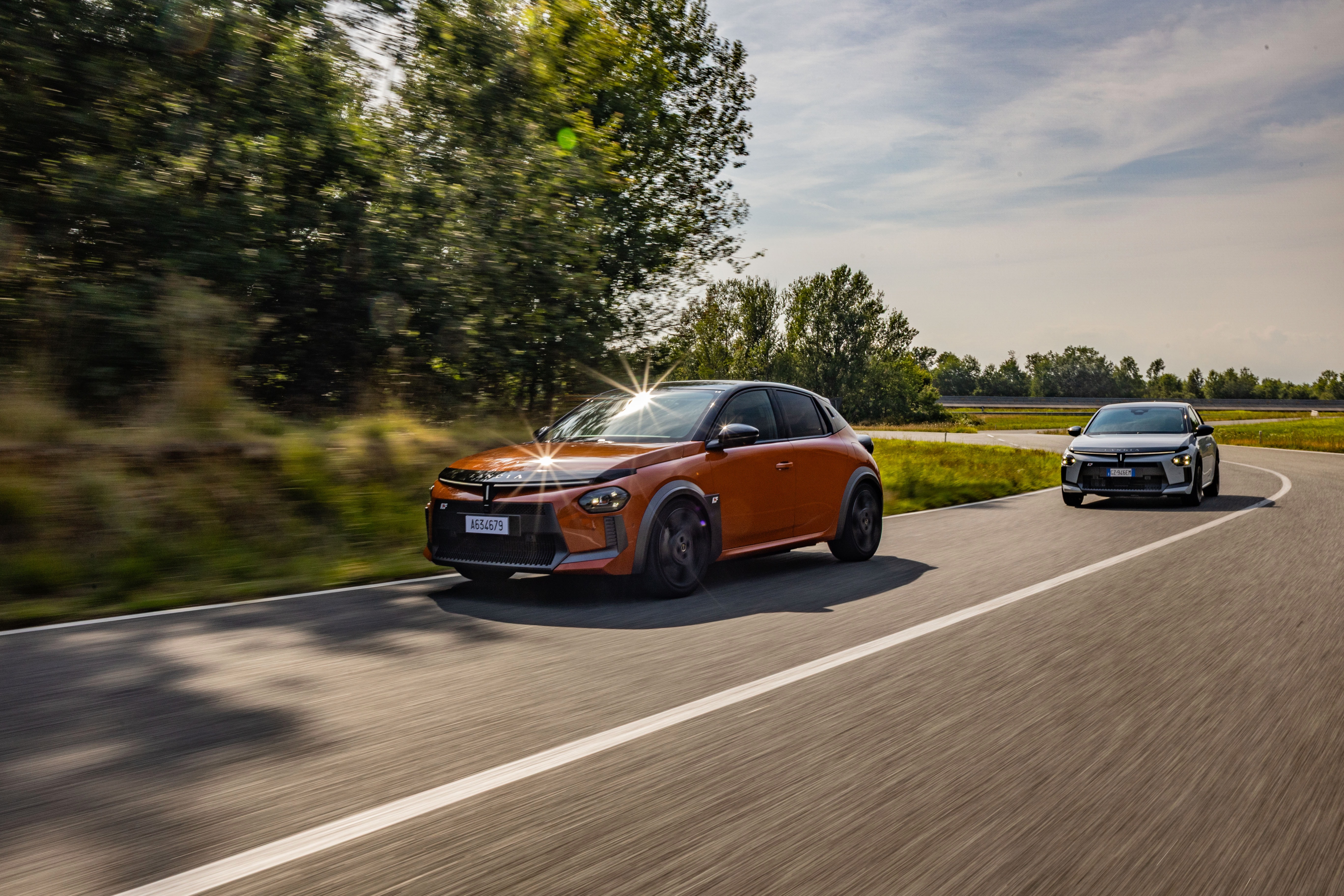 Vista lateral de dos Lancia Ypsilon en movimiento, destacando su agilidad y diseño.