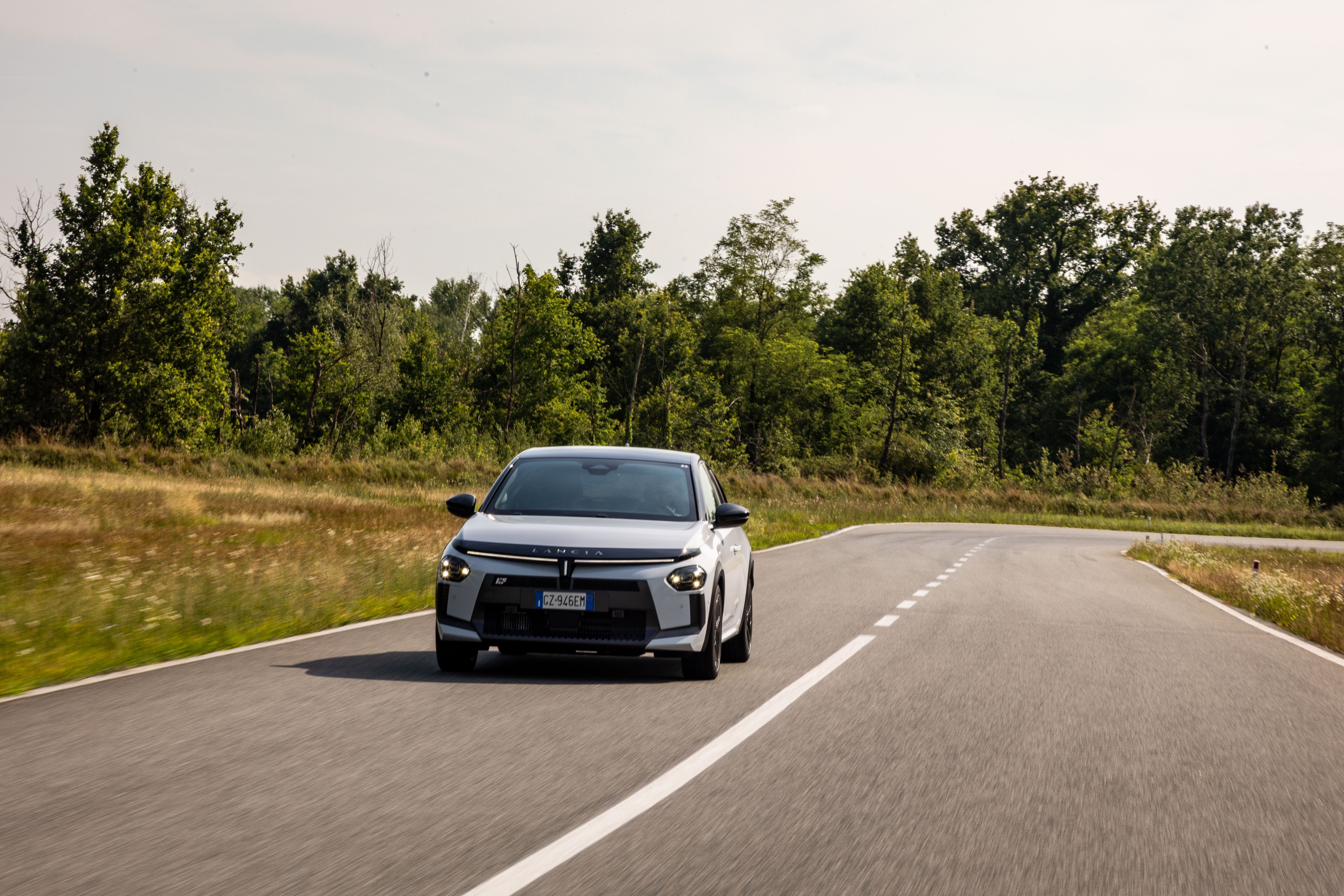 Vista trasera del Lancia Ypsilon en la carretera, mostrando su amplio diseño.
