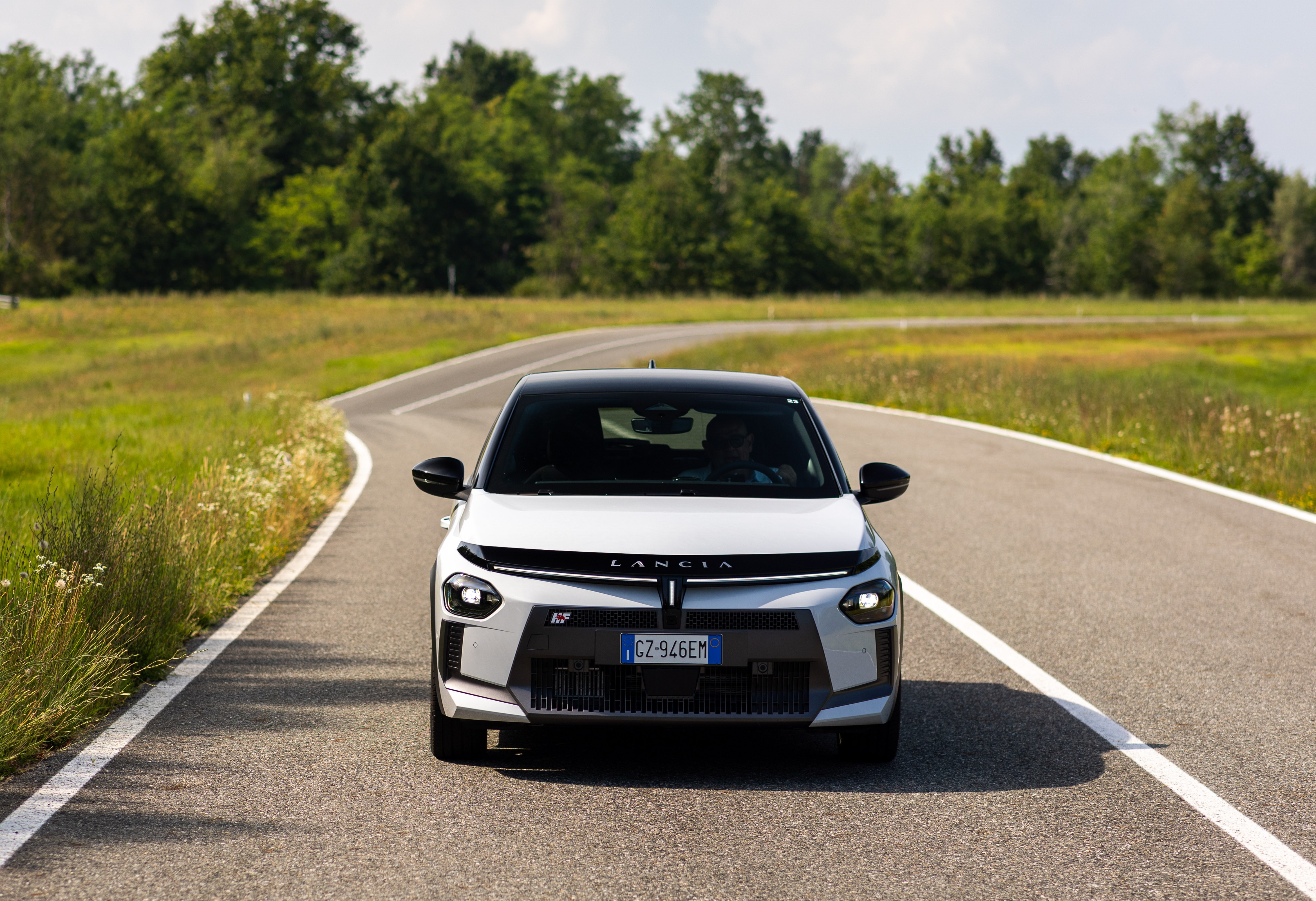 Frontal del coche en una carretera, mostrando su presencia en la vía.