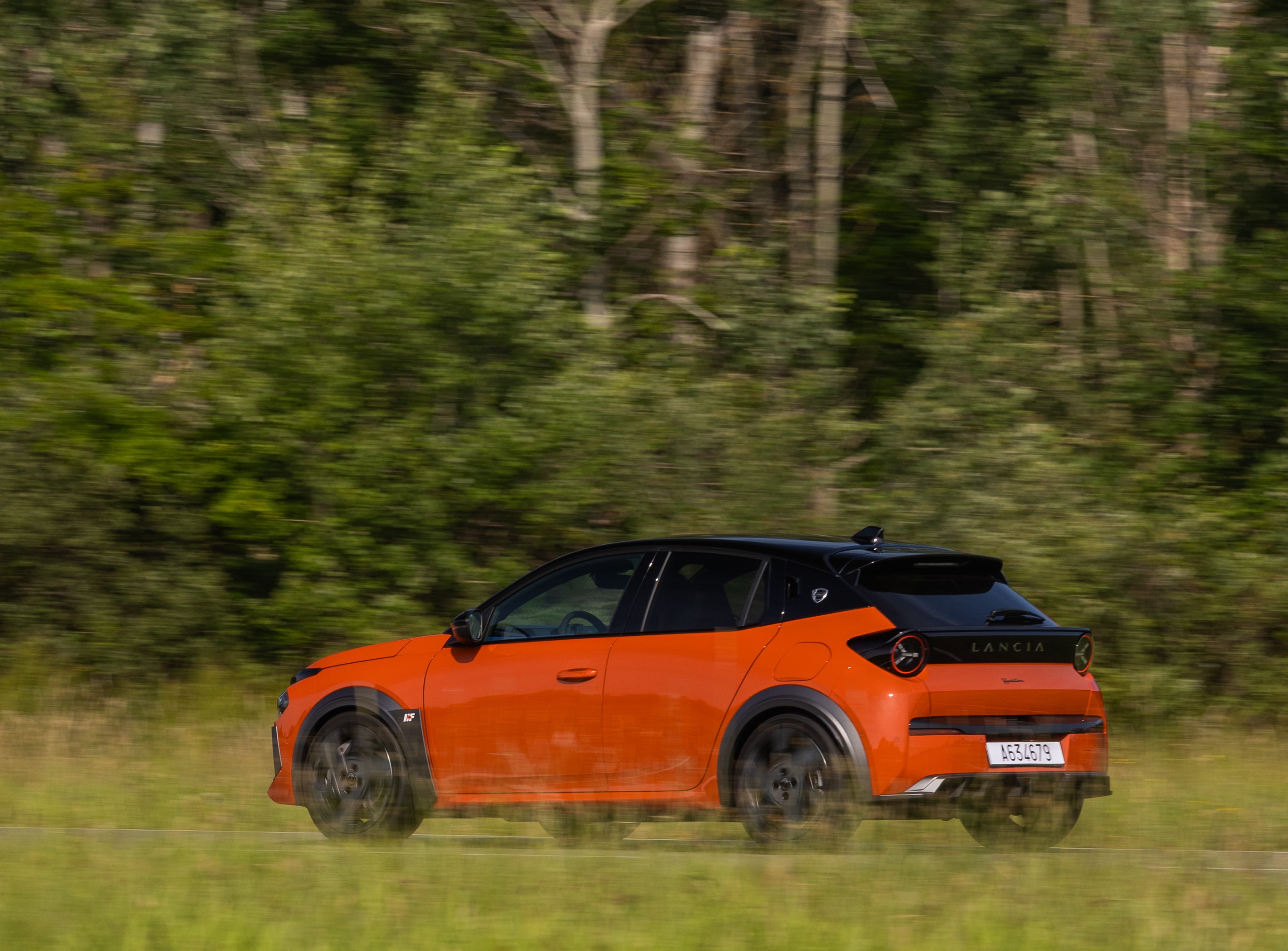 El Lancia Ypsilon naranjado en movimiento, destacando su vivaz estética.