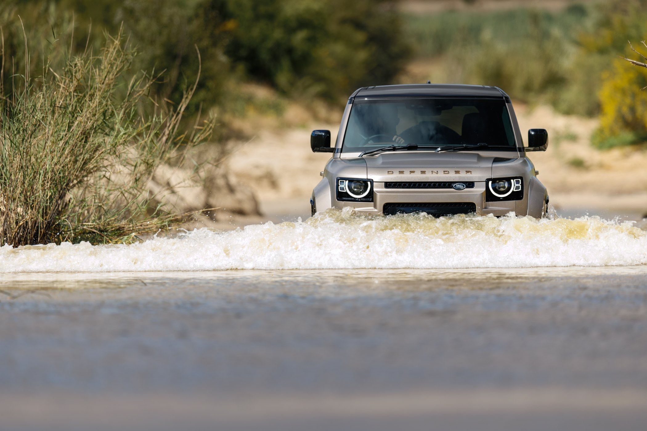 Land Rover Defender Híbrido en una carretera montañosa, esencial para aventuras.