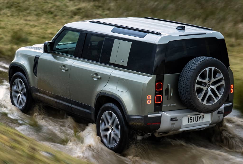 Land Rover Defender híbrido vadeando un río con habilidad.