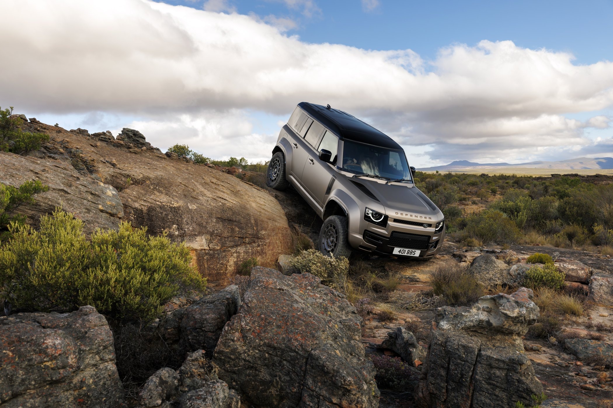 El Land Rover Defender Híbrido en un terreno rocoso, mostrando su capacidad off-road.