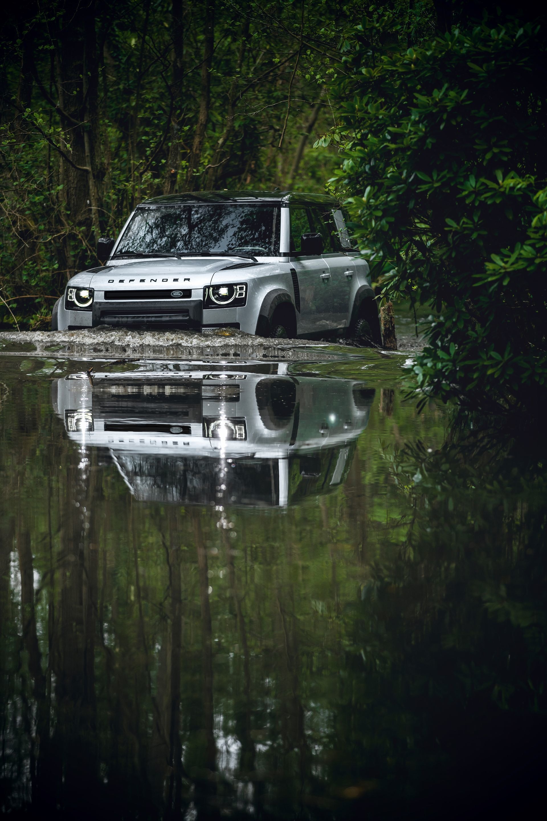Elegante reflejo del Defender en aguas tranquilas.