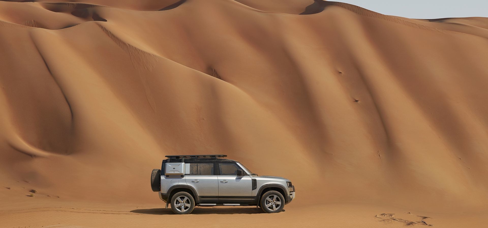 El Defender solo en la inmensidad del desierto, destacando su independencia.