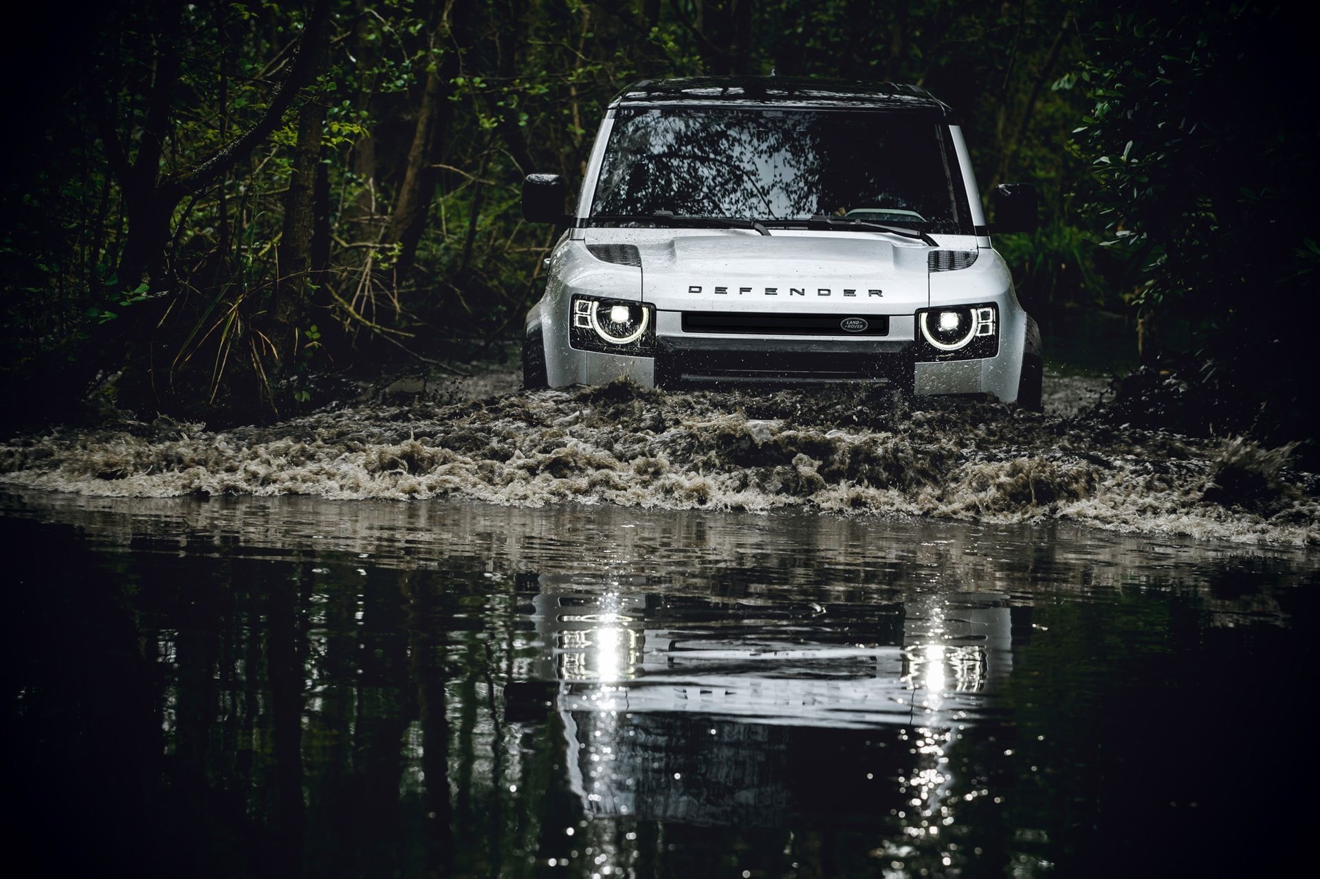 Imagen trasera del Land Rover Defender cruzando un río.