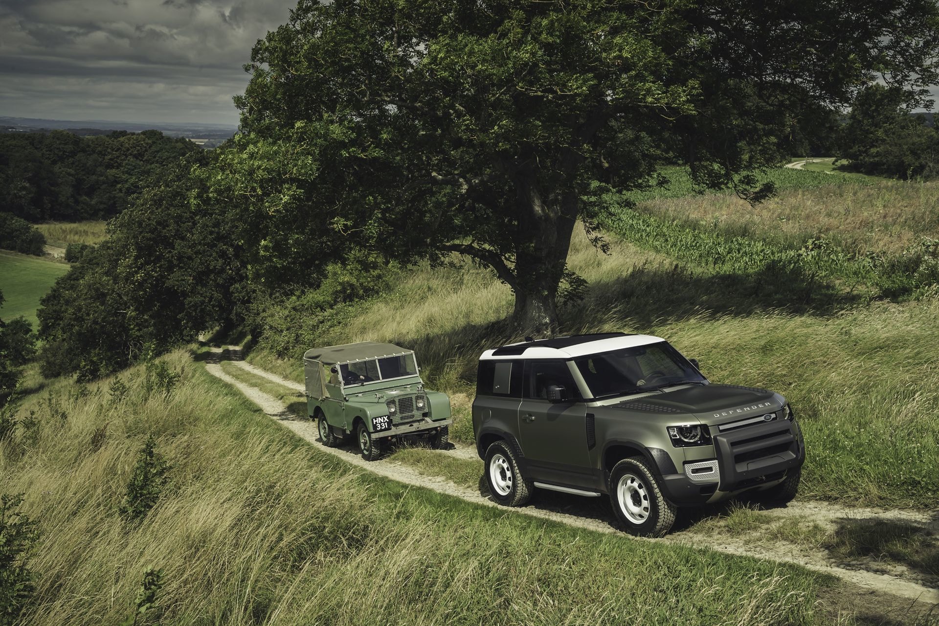 Legacy Defender junto a la última generación en paisaje verde.