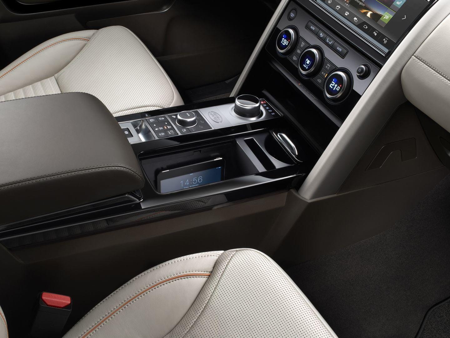 Consola central Land Rover Discovery con controles ergonómicos y almacenamiento.