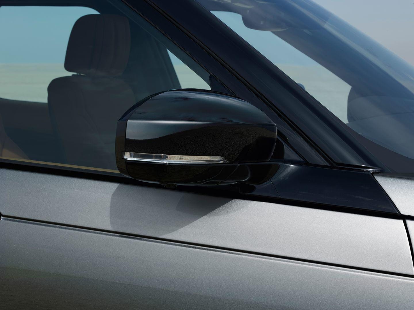 Espejo retrovisor exterior de un Land Rover Discovery destacando su diseño aerodinámico.