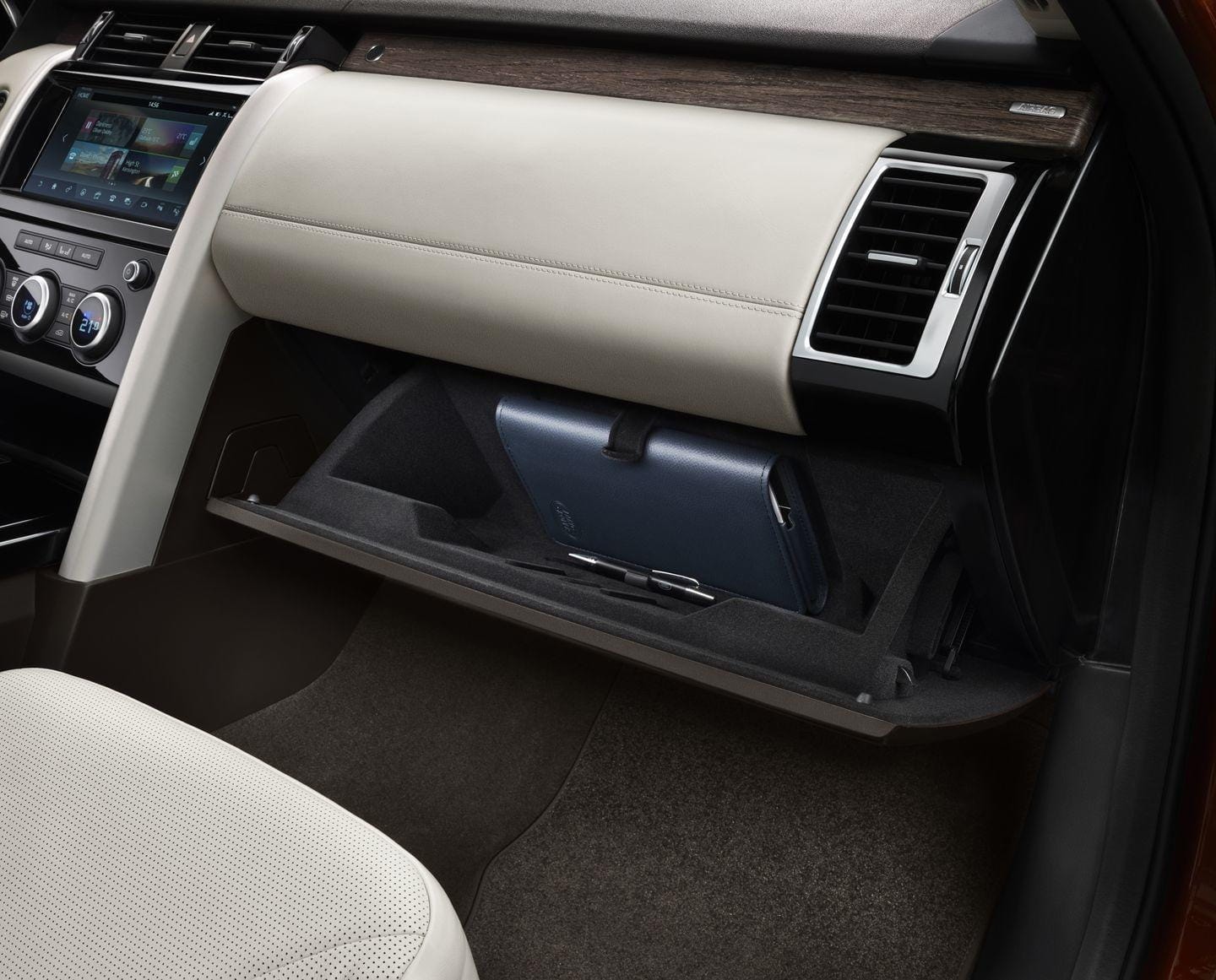 Imagen de la guantera abierta del Land Rover Discovery mostrando espacio interior.