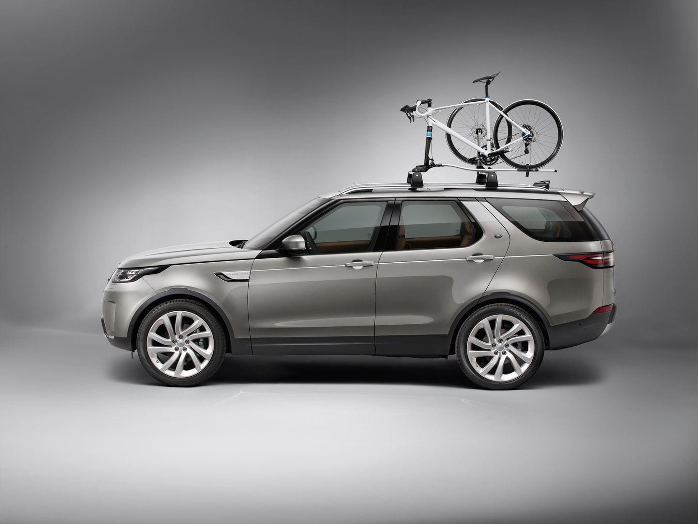 Vista lateral del Land Rover Discovery con portabicicletas en el techo.