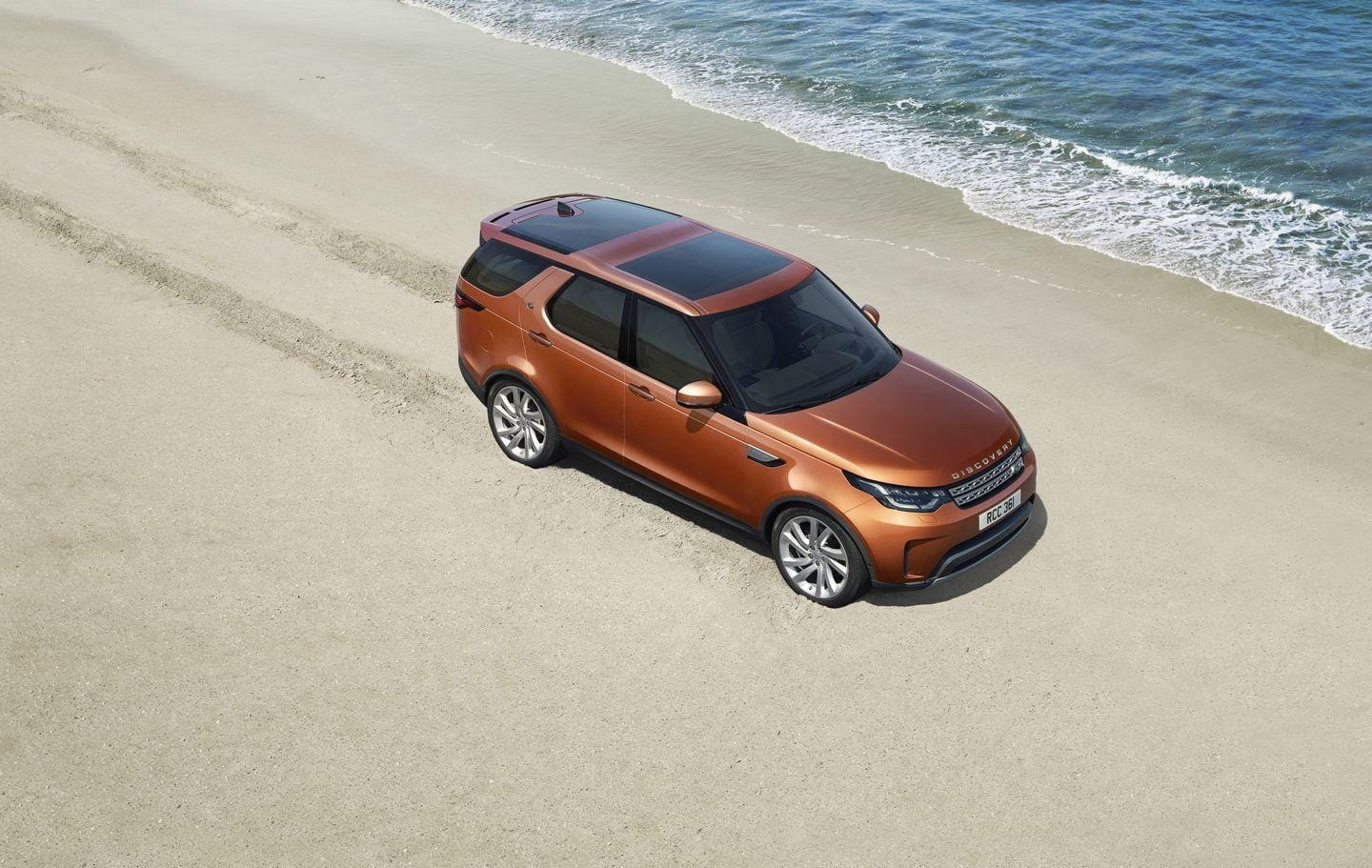 Vista aérea Land Rover Discovery en un entorno de playa.