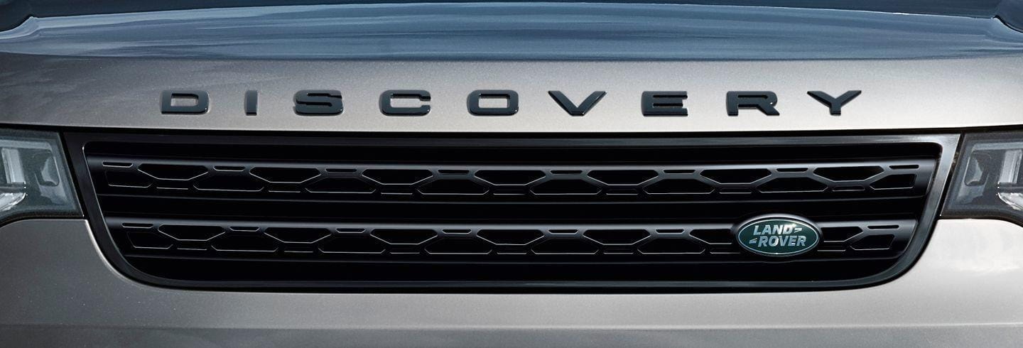 Vista frontal del Land Rover Discovery, resaltando su parrilla y el distintivo en relieve.