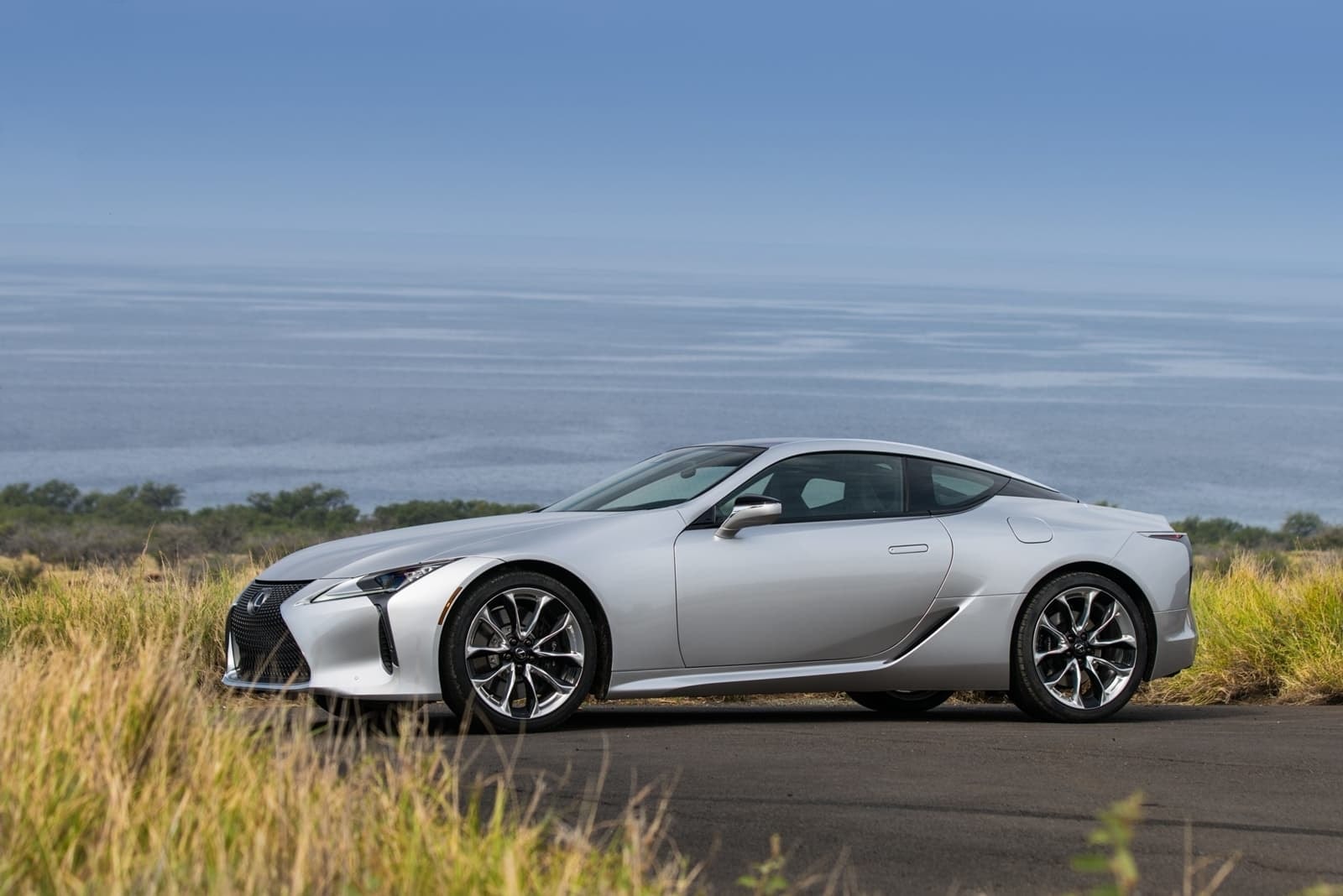 Silueta del Lexus LC híbrido contrastando con una carretera y paisaje despejado.