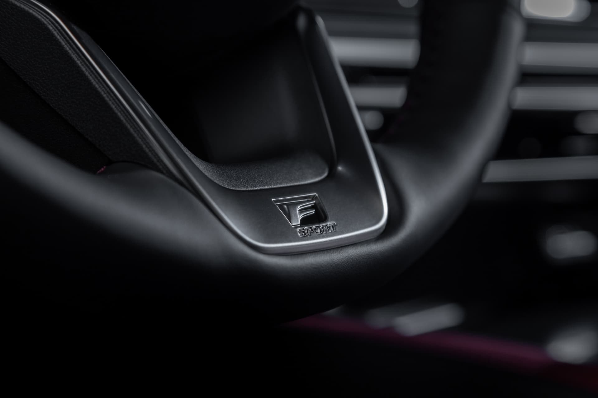 Detalle del emblema F Sport en el volante, un toque de distinción deportiva.