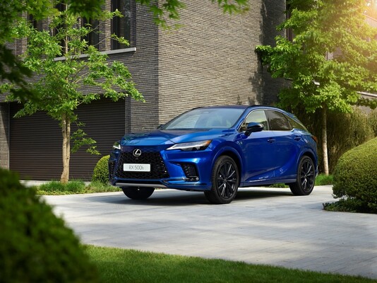 Lexus RX híbrido azul estacionado en un entorno residencial.