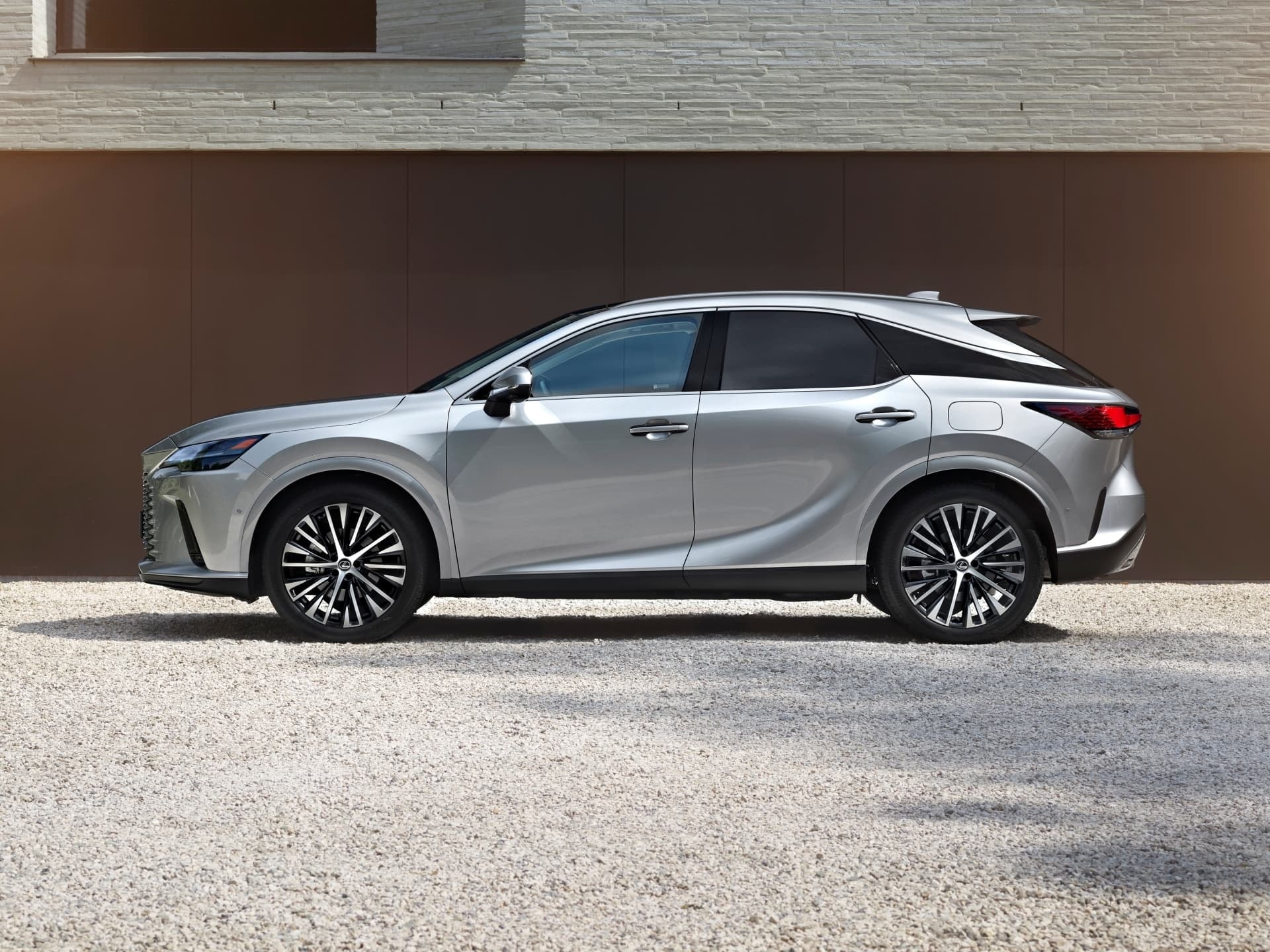 Perfil elegante del Lexus RX híbrido con llantas distintivas y dinámicas líneas.