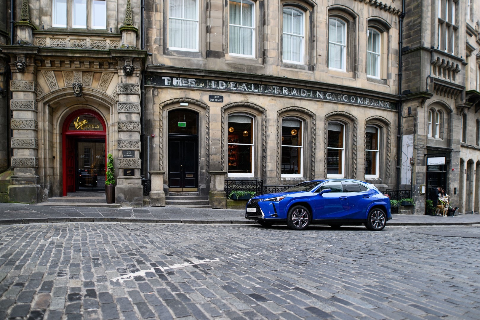 Lexus UX300e en un entorno urbano histórico, destacando su diseño moderno.