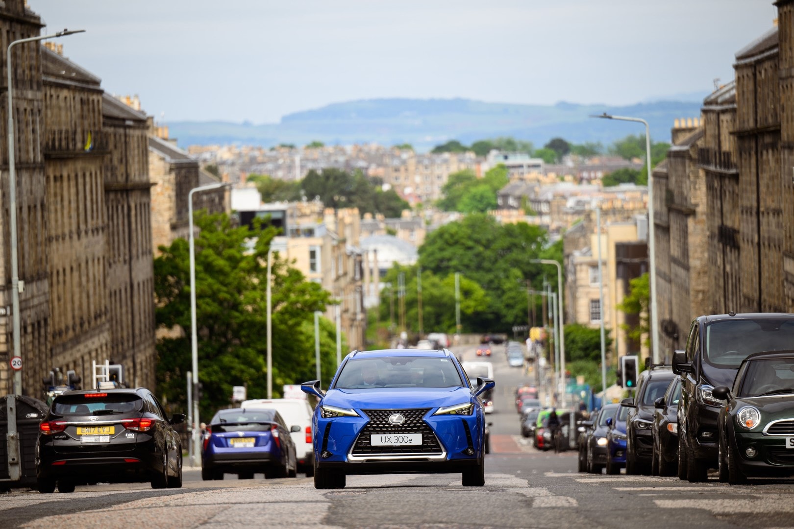 Imagen del Lexus UX300e avanzando entre callejones urbanos, mostrando el diseño de su parrilla.