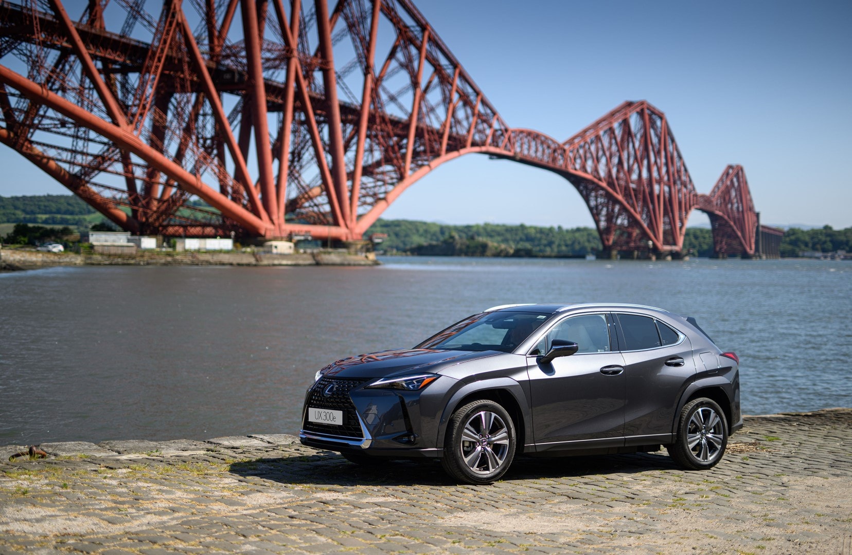 Lexus UX300e perfilado con el icónico Forth Bridge de fondo.
