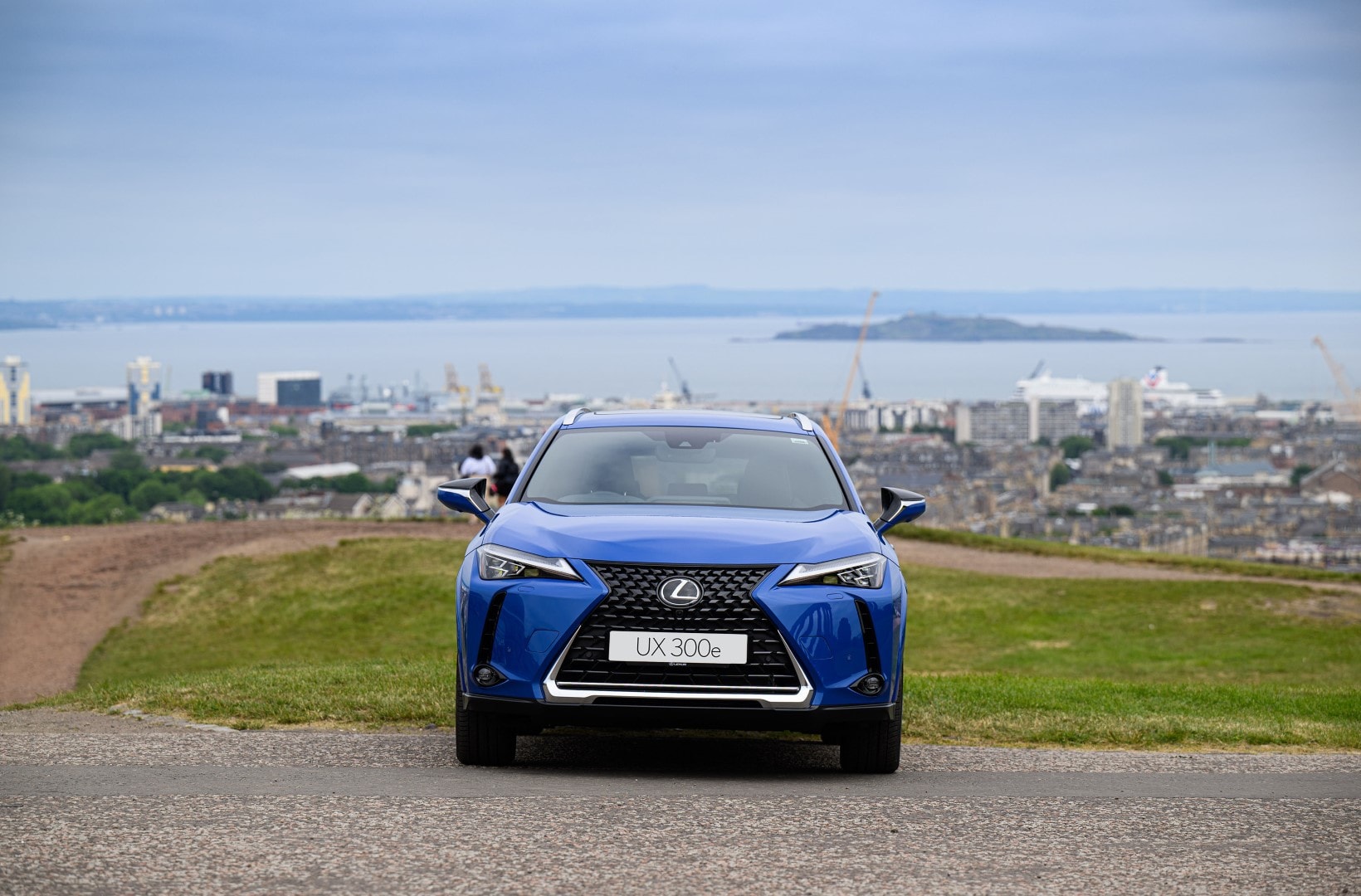 Lexus UX300e frente a un paisaje urbano amplio, enfatizando su contextura dentro de la ciudad.